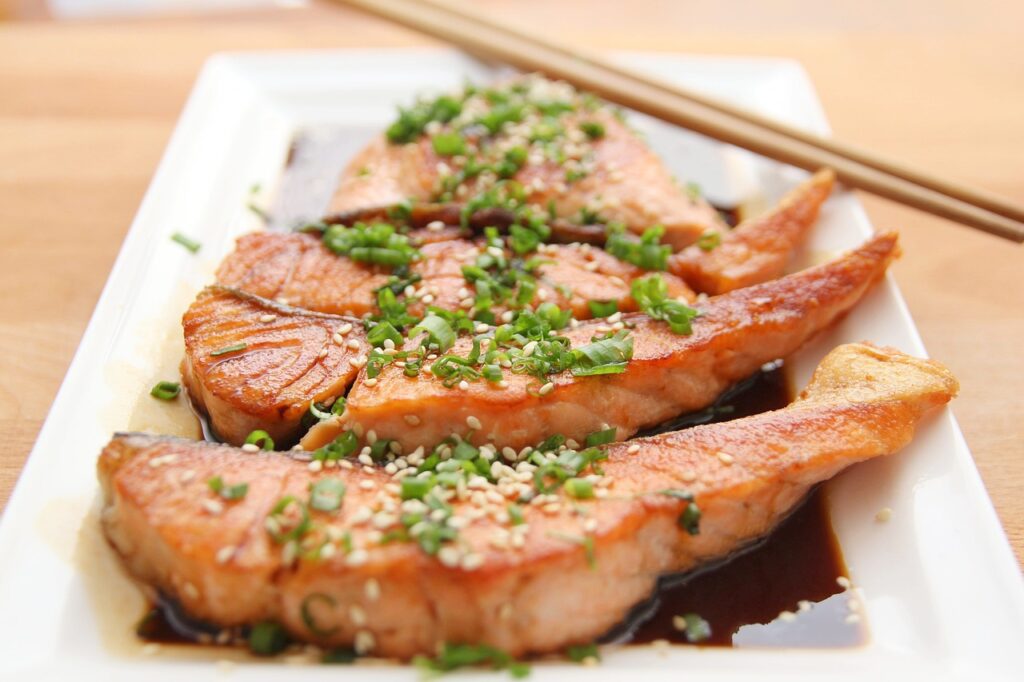 salmon steaks and chopsticks on a white plate