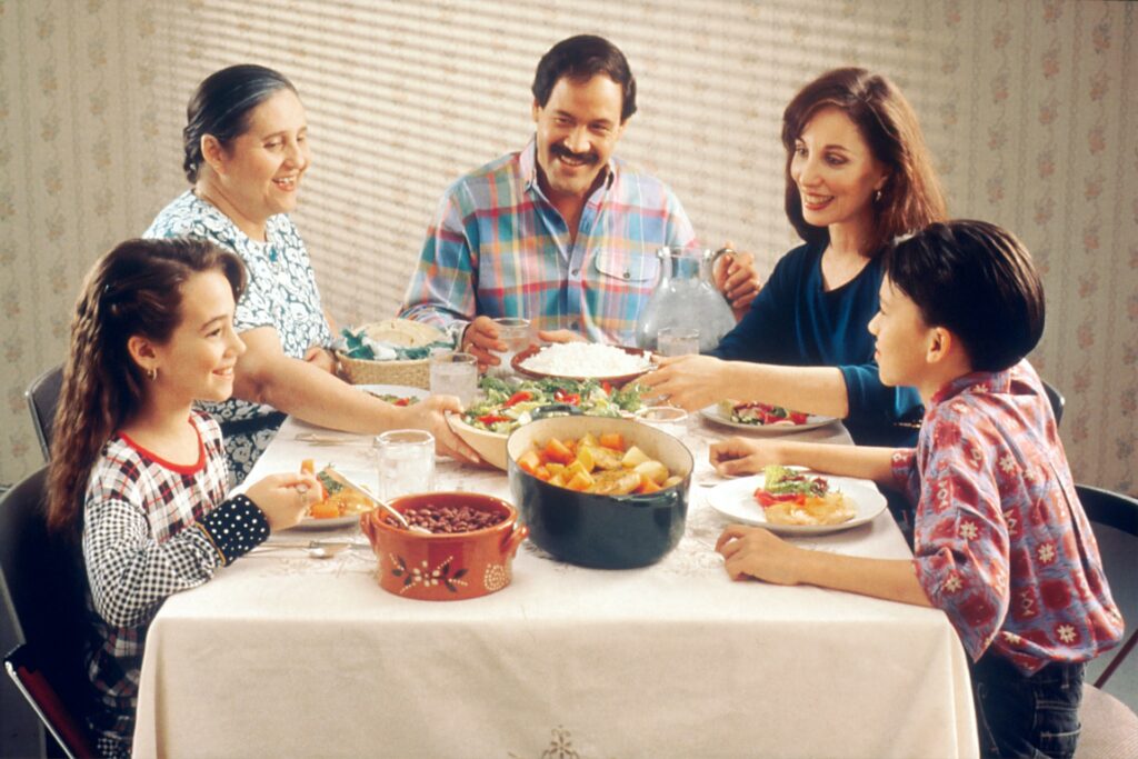 mum, dad, 2 kids and grandma sitting around the kitchen table