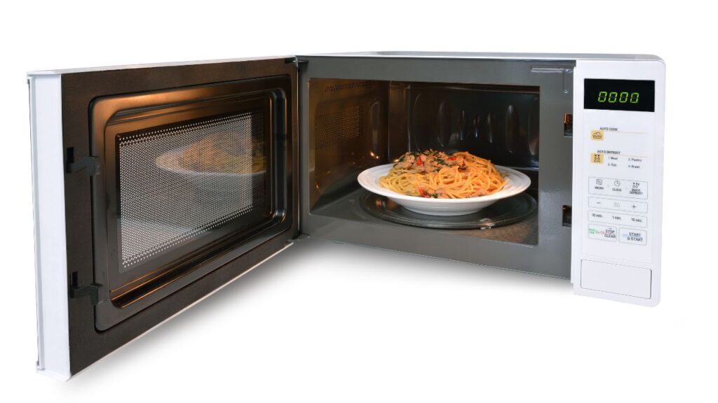 microwave with door open, revealing a bowl of spaghetti on the turntable